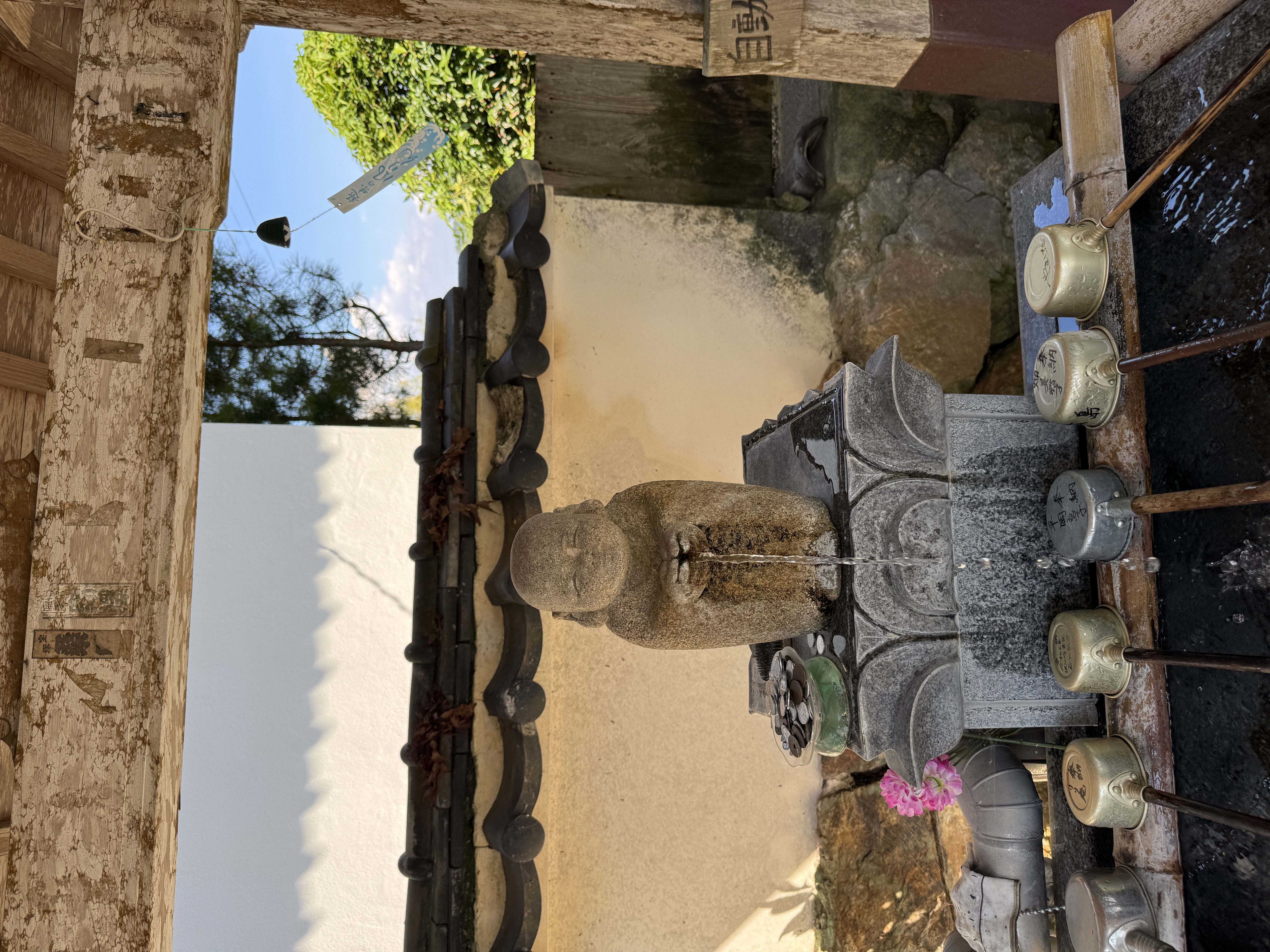 狸の石像と風鈴のある手水場